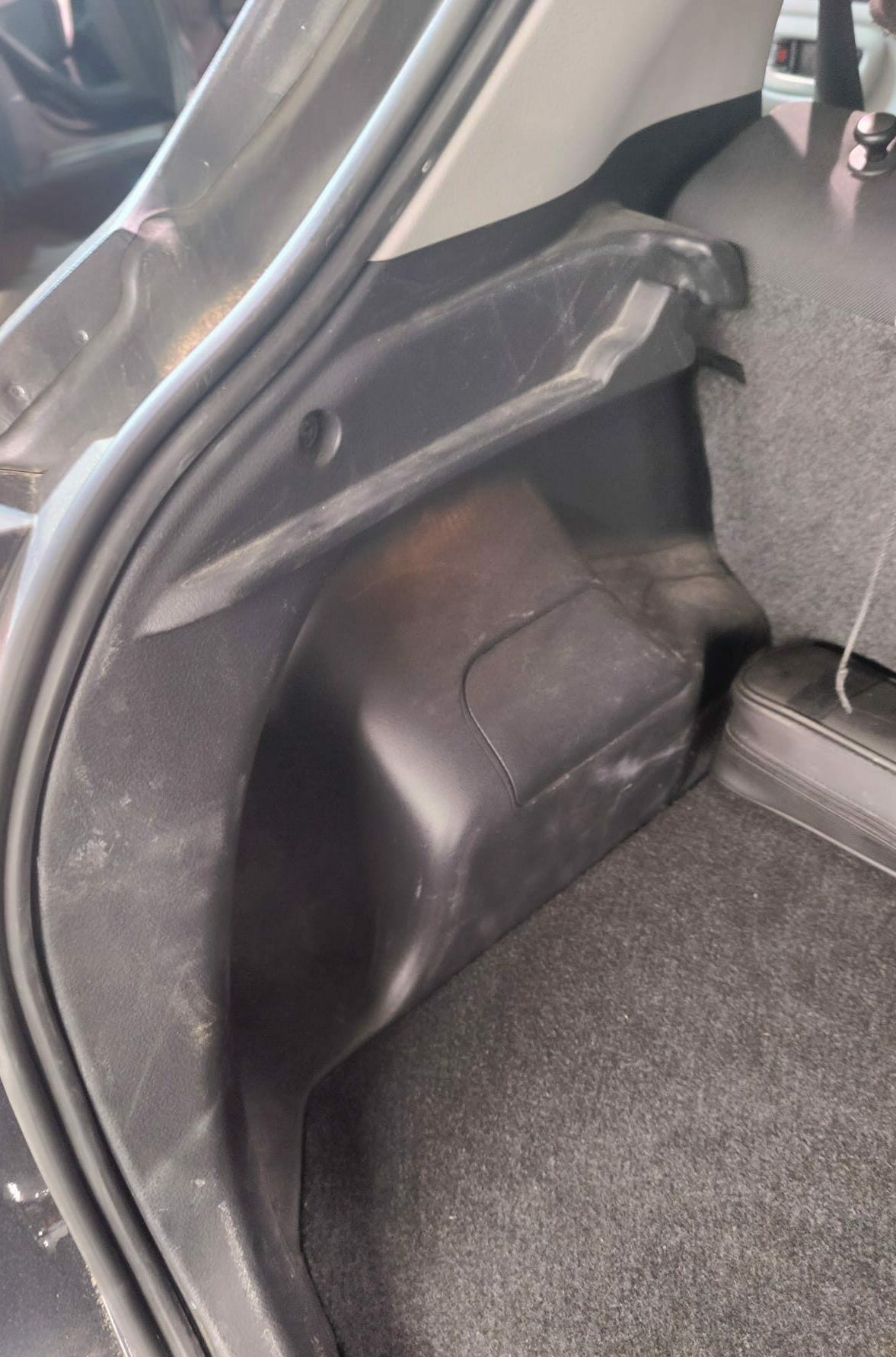 Clean'Ride - Rénovation esthétique & nettoyage automobile Plastique de garniture de coffre latéral terni, abîmé et rayé avant rénovation - Clean'Ride Hérault